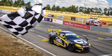 Simon Baker crossing finish line in Mazda RX8 at Ruapuna